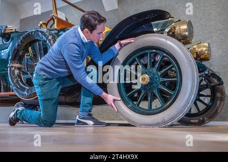 Londres, Royaume-Uni. 31 octobre 2023. Un membre du personnel avec un Isotta-Fraschini Tipo PM Roadster 1912, estimation : £400,000-£450,000, en avant-première pour la Bonhams Cars Golden Age of Motoring sale. Sur les 31 véhicules offerts dans la vente, 21 sont antérieurs à 1905 et sont admissibles à la course des voitures anciennes de Londres à Brighton. La vente a lieu le 3 novembre dans les galeries Bonhams New Bond Street. Crédit : Stephen Chung / Alamy Live News Banque D'Images