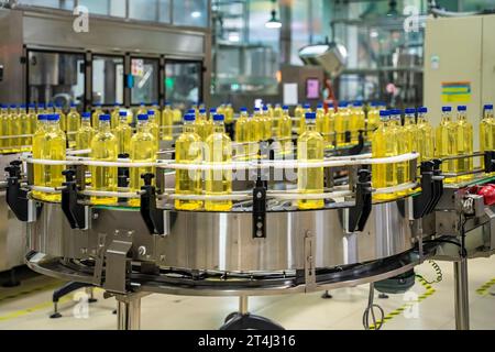Huile de cuisson ou huile de tournesol dans la bouteille se déplaçant sur la chaîne de production, usine à Ho Chi Minh ville, Vietnam Banque D'Images