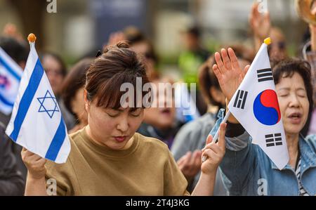 Séoul, Corée du Sud. 31 octobre 2023. Une partisane sud-coréenne d'Israël brandit des drapeaux alors qu'elle prie lors d'un rassemblement pour la paix en Israël près de l'ambassade israélienne dans le centre de Séoul. Un groupe chrétien sud-coréen soutenant Israël a organisé un rassemblement pour la paix en Israël près de l'ambassade israélienne dans le centre de Séoul. Crédit : SOPA Images Limited/Alamy Live News Banque D'Images