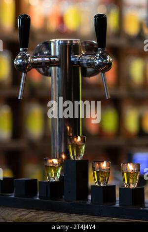 Les bougies à l'huile de Hanukkah brûlent à côté des robinets de bière dans un bar du marché Machane Yehuda à Jérusalem pendant la célébration de la Fête de la lumière Banque D'Images