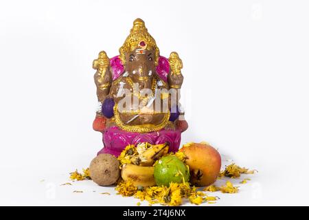 Ganesh Chaturthi est célébré avec une idole d'argile de Ganesh et des fleurs et des fruits sur fond blanc. Banque D'Images