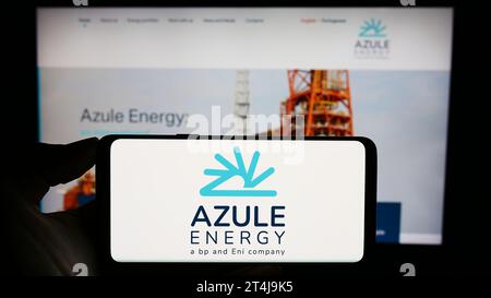 Personne tenant un téléphone portable avec le logo de la compagnie pétrolière angolaise Azule Energy devant la page Web de l'entreprise. Concentrez-vous sur l'affichage du téléphone. Banque D'Images