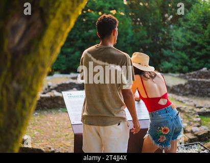 Jeune couple multiracial de derrière aux ruines de la ville antique tandis que le coucher du soleil en été Banque D'Images