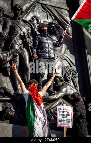 Un manifestant brandit le drapeau de la Palestine lors de la manifestation pro-palestinienne à Trafalgar Square Banque D'Images