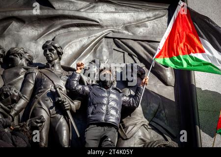 Un manifestant brandit le drapeau de la Palestine lors de la manifestation pro-palestinienne à Trafalgar Square Banque D'Images