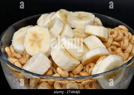 Céréales de petit déjeuner avec banane coupée dans un bol en verre. Banque D'Images