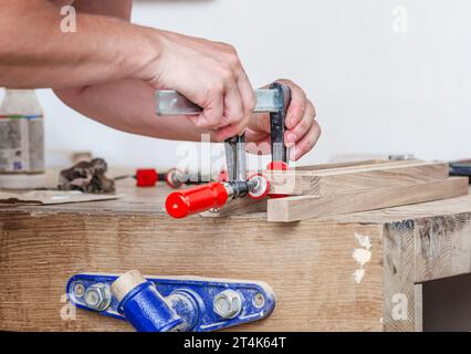 Les pinces de charpentier sont fixées aux planches. Collage de menuiserie dans l'atelier Banque D'Images