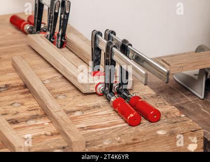 Les pinces de charpentier sont fixées aux planches. Collage de menuiserie dans l'atelier Banque D'Images