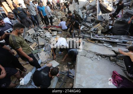 Gaza. 31 octobre 2023. Les gens recherchent des survivants parmi les décombres des bâtiments détruits lors des frappes aériennes israéliennes dans la ville de Rafah, dans le sud de la bande de Gaza, le 31 octobre 2023. Le conflit en cours entre Israël et le Hamas a tué plus de 8 525 Palestiniens et 1 400 Israéliens, selon les chiffres officiels des deux parties. Crédit : Khaled Omar/Xinhua/Alamy Live News Banque D'Images