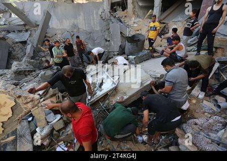 Gaza. 31 octobre 2023. Les gens recherchent des survivants parmi les décombres des bâtiments détruits lors des frappes aériennes israéliennes dans la ville de Rafah, dans le sud de la bande de Gaza, le 31 octobre 2023. Le conflit en cours entre Israël et le Hamas a tué plus de 8 525 Palestiniens et 1 400 Israéliens, selon les chiffres officiels des deux parties. Crédit : Khaled Omar/Xinhua/Alamy Live News Banque D'Images