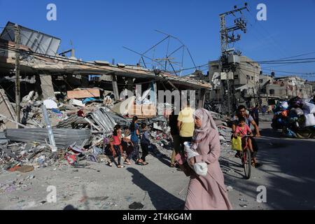 Gaza. 31 octobre 2023. Des gens sont vus près des décombres de bâtiments détruits lors des frappes aériennes israéliennes dans la ville de Rafah, dans le sud de la bande de Gaza, le 31 octobre 2023. Le conflit en cours entre Israël et le Hamas a tué plus de 8 525 Palestiniens et 1 400 Israéliens, selon les chiffres officiels des deux parties. Crédit : Khaled Omar/Xinhua/Alamy Live News Banque D'Images