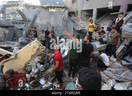 Gaza. 31 octobre 2023. Les gens recherchent des survivants parmi les décombres des bâtiments détruits lors des frappes aériennes israéliennes dans la ville de Rafah, dans le sud de la bande de Gaza, le 31 octobre 2023. Le conflit en cours entre Israël et le Hamas a tué plus de 8 525 Palestiniens et 1 400 Israéliens, selon les chiffres officiels des deux parties. Crédit : Khaled Omar/Xinhua/Alamy Live News Banque D'Images