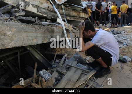 Gaza. 31 octobre 2023. Un homme squatte parmi les décombres des bâtiments détruits lors des frappes aériennes israéliennes dans la ville de Rafah, dans le sud de la bande de Gaza, le 31 octobre 2023. Le conflit en cours entre Israël et le Hamas a tué plus de 8 525 Palestiniens et 1 400 Israéliens, selon les chiffres officiels des deux parties. Crédit : Khaled Omar/Xinhua/Alamy Live News Banque D'Images