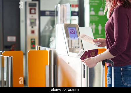 Passager vérifiant son passeport en toute sécurité à la porte automatisée de l'aéroport - documents de voyage Banque D'Images