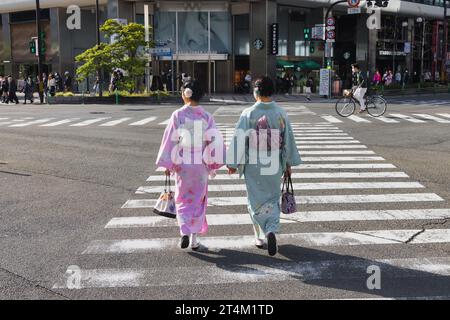 Kyoto, Japon - 17 avril 2023 : de jeunes japonaises non identifiées en kimono traditionnel traversent une rue près de la gare de Kyoto. Le kimono est la nationa Banque D'Images