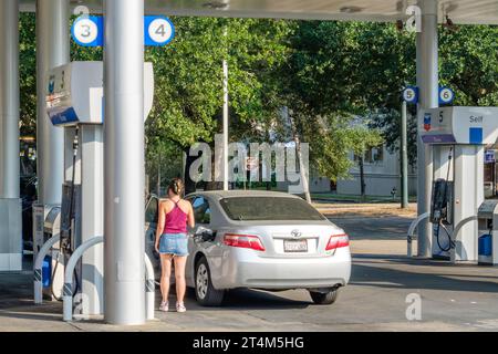 LA NOUVELLE-ORLÉANS, LA, USA - 18 AOÛT 2023 : jeune femme remplissant le réservoir d'essence de sa voiture à une station Chevron dans le quartier de Carrollton Banque D'Images