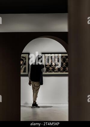 Bangkok, Thaïlande. Fév - 06, 2022 : vue arrière du jeune homme asiatique se tenant intéressé par la photographie affichée sur le mur blanc à la galerie d'art exposition h Banque D'Images