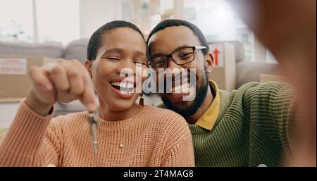 Couple noir, portrait et selfie avec clés dans une nouvelle maison après déménagement et déménagement. Sourire, montrer et un homme et une femme africains excités par un Banque D'Images