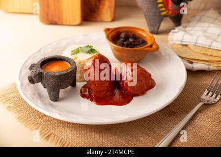 Rouleaux de viande avec adobo, farcis avec du fromage, des légumes ou d'autres ingrédients, et servis avec du riz et des haricots, également appelés au Mexique comme enfant enveloppé ou Banque D'Images