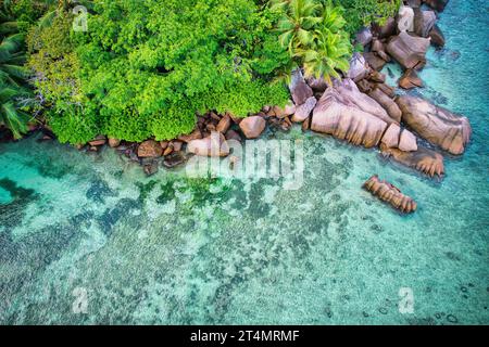 Drone oeil d'oiseau de la plage de baie lazare, pierres de granit, eau turquoise, cocotiers, journée ensoleillée, Mahe Seychelles Banque D'Images