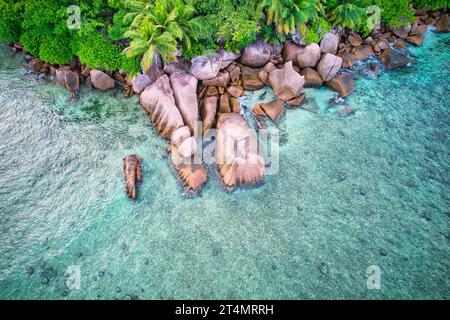 Drone oeil d'oiseau de la plage de baie lazare, pierres de granit, eau turquoise, cocotiers, journée ensoleillée, Mahe Seychelles Banque D'Images