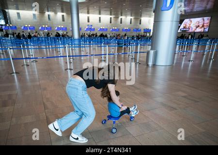 Tel Aviv, Israël. 31 octobre 2023. Une passagère joue avec son enfant à l’aéroport international Ben Gourion près de tel Aviv, Israël, le 31 octobre 2023. L'aéroport international Ben Gourion a vu son trafic de passagers diminuer en raison du conflit israélo-palestinien en cours. Crédit : Chen Junqing/Xinhua/Alamy Live News Banque D'Images