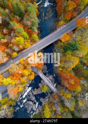 Vue aérienne des anciens et nouveaux ponts traversant la rivière Moriston entourée de bois aux couleurs automnales à Invermoriston, Écosse Royaume-Uni Banque D'Images