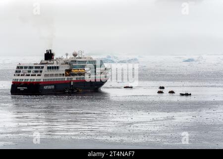 navire de croisière hurtigruten et zodiacs opérant dans les eaux glacées de la baie de charlotte sur la côte de danco. péninsule antarctique. antarctique Banque D'Images