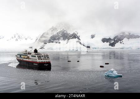 navire de croisière hurtigruten et zodiacs opérant dans les eaux glacées de la baie de charlotte sur la côte de danco. péninsule antarctique. antarctique Banque D'Images