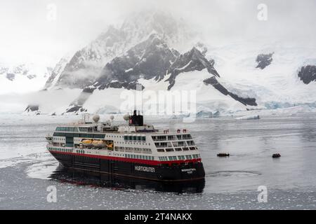 navire de croisière hurtigruten et zodiacs opérant dans les eaux glacées de la baie de charlotte sur la côte de danco. péninsule antarctique. antarctique Banque D'Images