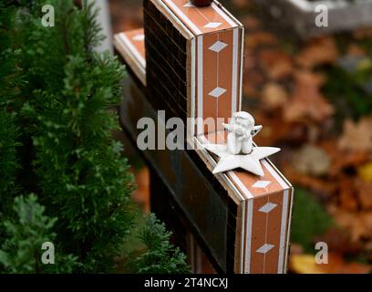 Cologne, Allemagne. 01 novembre 2023. Une pierre tombale est décorée d'une figure d'ange le jour de la Toussaint sur une tombe dans le cimetière de Melaten. Les catholiques commémorent leur défunt en cette fête. Crédit : Roberto Pfeil/dpa/Alamy Live News Banque D'Images