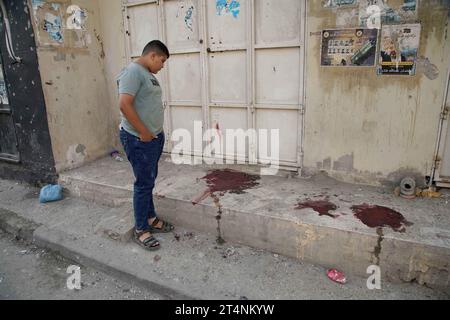 Djénine, Territoires palestiniens. 01 novembre 2023. Un palestinien se tient devant des taches de sang après de violents affrontements lors d’un raid israélien dans le camp de réfugiés de Djénine. Crédit : Stringer/dpa/Alamy Live News Banque D'Images