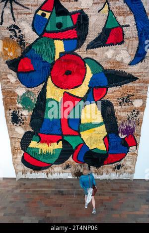 Visiteur devant une tapisserie de la Fondation Joan Miro, Barcelone, Espagne Banque D'Images