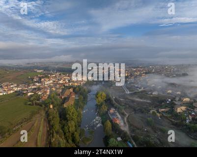 Vue aérienne du village de Roda de Ter entouré de brouillard un matin d'automne dans la Plana de Vic (Osona, Barcelone, Catalogne, Espagne) Banque D'Images