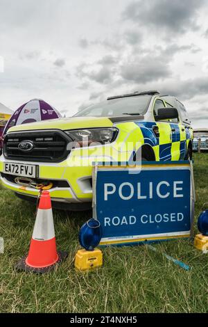 Nantwich, Cheshire, Angleterre, 26 juillet 2023. Police Ford Ranger van avec des cônes de signalisation et le panneau bleu de route fermé. Banque D'Images