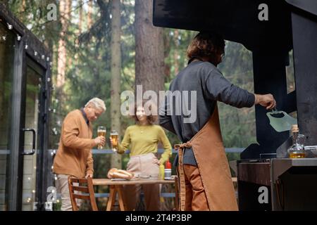 Groupe de jeunes amis ayant barbecue dans la forêt en plein air Banque D'Images