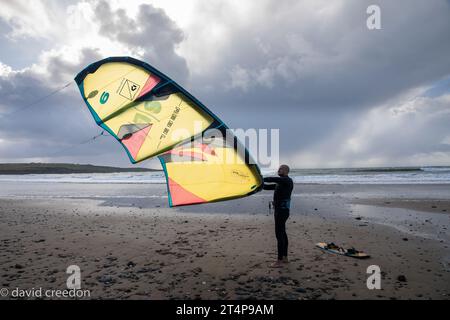 Garrettstown, Cork, Irlande. 01 novembre 2023. Alors que les vents augmentent avec l'arrivée imminente prévue de Storm Ciarán, le kitesurfer Andrew Jurgilas de Nohoval prépare son cerf-volant pour une matinée de surf à Garrettstown, Co. Cork.- crédit : David Creedon / Alamy Live News Banque D'Images