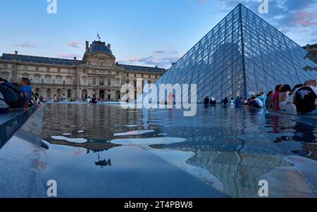 Vue sur les pyramides de verre du palais du Louvre au coucher du soleil Banque D'Images