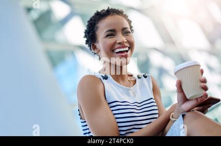 Shes sa propre patronne dame et elle adore ça. une jeune femme d'affaires attrayante riant tout en étant assise dans un lieu de travail moderne. Banque D'Images