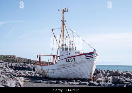 Keflavik, Islande - 11 juillet 2023 : le bateau de pêche Baldur (1961) s'échoue sur des rochers par une journée ensoleillée Banque D'Images