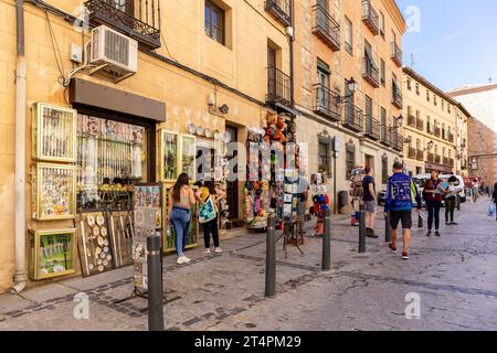 Tolède, Espagne, 08.10.21. Boutique de souvenirs sur une rue médiévale étroite avec poterie, épées médiévales, sacs et chapeaux en liège, cartes postales et touristes. Banque D'Images