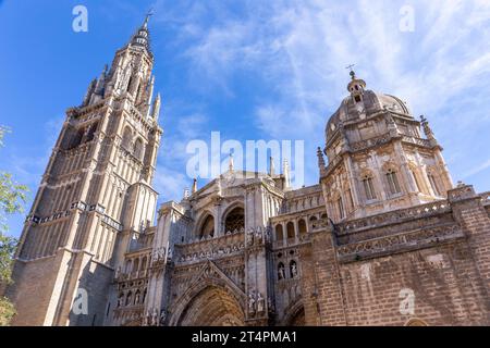 Cathédrale de Tolède, façade gothique de l'église avec portails, statues, reliefs, clocher et dôme de chapelle mozarabe vu de la Plaza del Ayuntamiento, Espagne. Banque D'Images