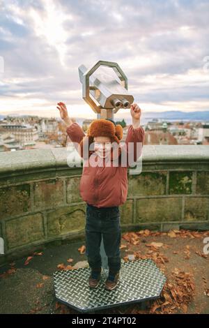 Petit enfant regardant des jumelles à pièces au point de vue dans la vieille ville européenne, voyage en famille avec des enfants Banque D'Images