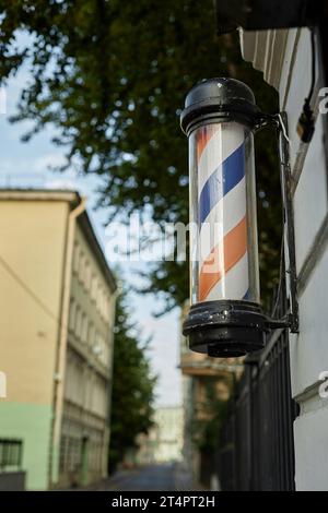 Image verticale de la lanterne rouge et bleue de salon de coiffure accrochée à la porte du bâtiment Banque D'Images