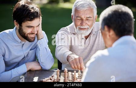 Je vous apprends les voies du monde des échecs. un groupe d'hommes jouant à une partie d'échecs dehors. Banque D'Images