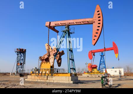 unité de pompage sous ciel bleu dans un champ pétrolifère Banque D'Images