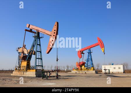 unité de pompage sous ciel bleu dans un champ pétrolifère Banque D'Images