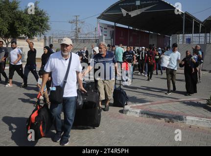 Rafah, Gaza. 31 octobre 2023. Les Palestiniens ayant la double nationalité entrent au poste frontalier de Rafah, dans le sud de la bande de Gaza, avant de passer en Égypte le mercredi 1 novembre 2023. Des dizaines de détenteurs de passeports étrangers piégés à Gaza ont commencé à quitter le territoire palestinien déchiré par la guerre lorsque le passage de Rafah vers l’Égypte a été ouvert pour la première fois depuis le 7 octobre. Photo par Ismael Mohamad/UPI crédit : UPI/Alamy Live News Banque D'Images