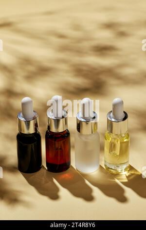 Divers cosmétiques spa, huiles pour massage du visage dans des bouteilles en verre noir, brun, clair et mat, beauté minimalisme et concept de thérapie de salon. Banque D'Images