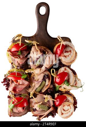 Ensemble de canapés assortis avec rouleau de poulet, jambon cuit au four et légumes servis sur une planche à découper en bois avec romarin frais. Isolé sur fond blanc. Banque D'Images